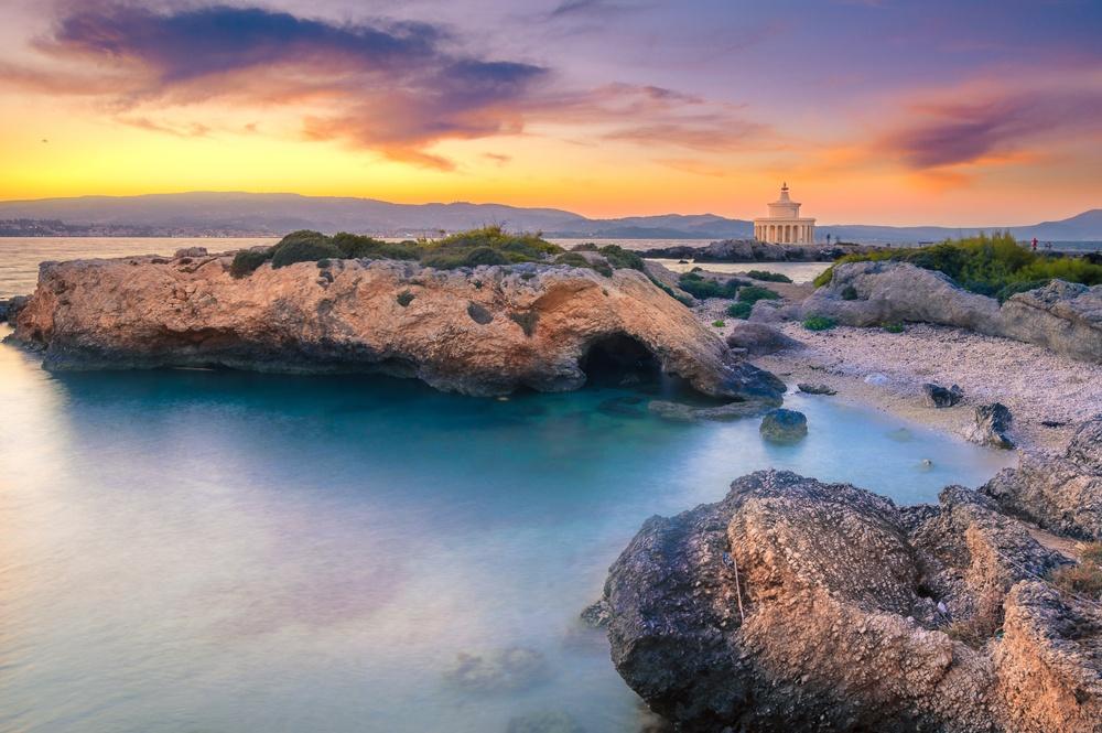 A rock arch on a Kefalonia beach at sunset