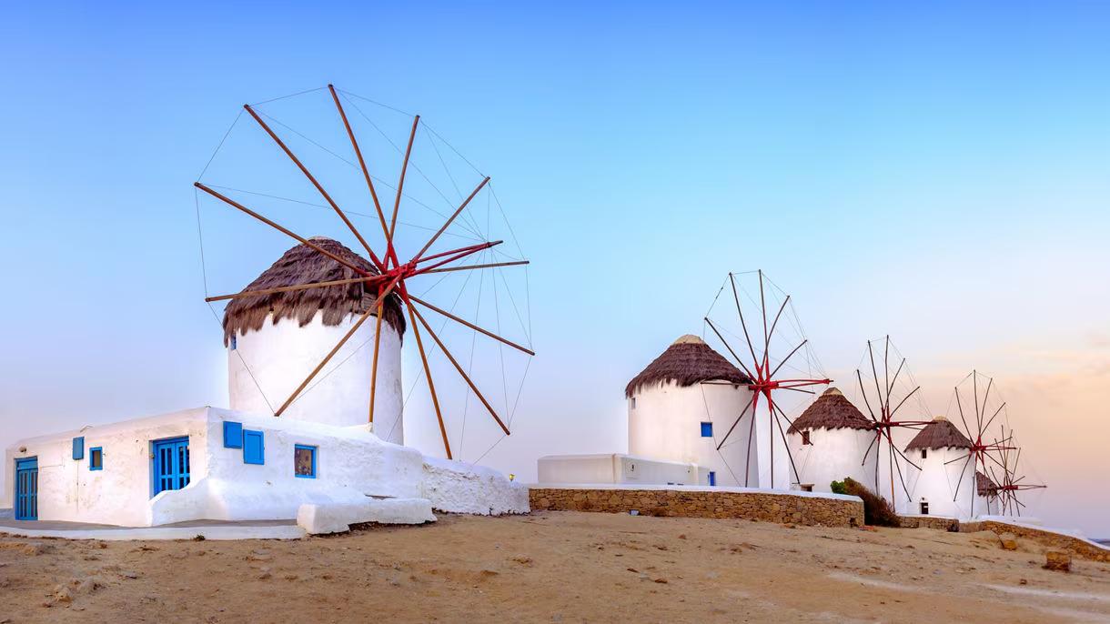 The windmills above Chora on Mykonos, with whitewashed buildings running down to the water.
