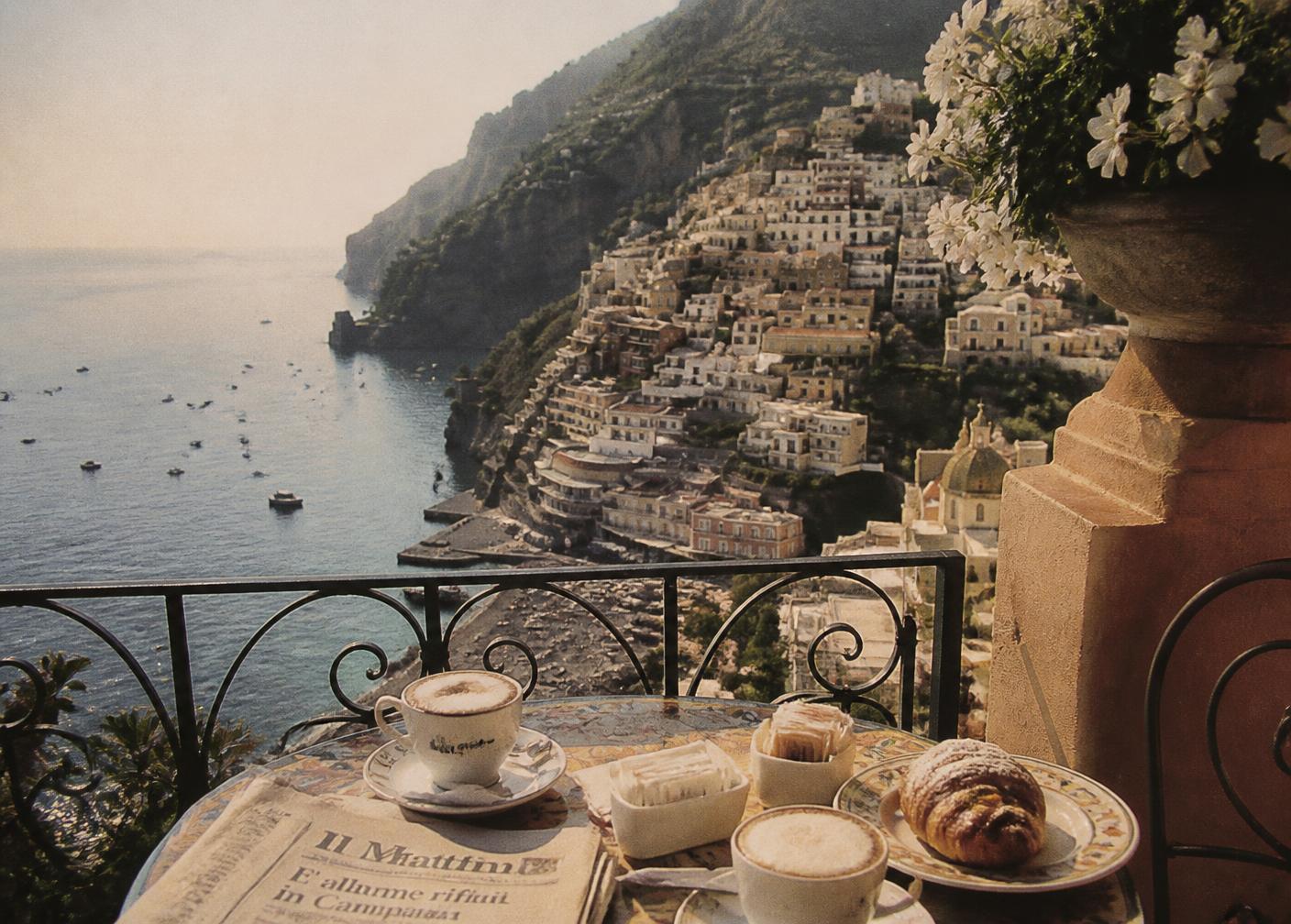 Cappuccino and pastries on a balcony table overlooking the Amalfi Coast at breakfast
